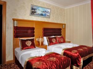 イスタンブールにあるAlfa Hotelの赤いカバーのベッド2台が備わるホテルルームです。