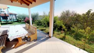 a table and bench on a porch with a view at Apartments Goga in Umag