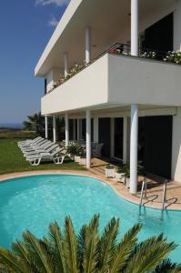 a house with a swimming pool in front of it at Vivenda Belo Horizonte in Caniço