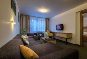 a living room with two couches and a desk at Hotel Diery in Terchová