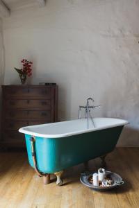 - une baignoire verte et blanche dans la chambre dans l'établissement WUNDERGARTEN Dimora dei Frati, à Gratteri