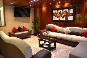 a living room with couches and chairs and a table at Hotel Royal Inn in Tacna
