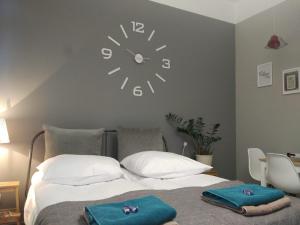 a bedroom with a bed with a clock on the wall at Apartament Easy Stay Center in Wrocław