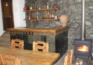 a fireplace in a room with a table and a stove at Maia's Guesthouse in Chvabiani
