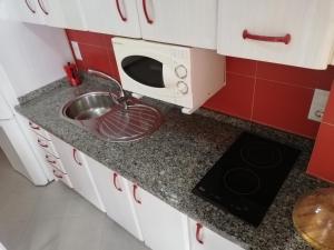 a kitchen counter with a sink and a microwave at Apartamento centro in Antequera