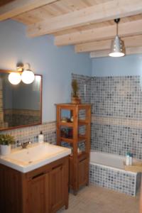 La salle de bains est pourvue d'un lavabo, d'un miroir et d'une baignoire. dans l'établissement Casa Rural Leonor con piscina privada, à Casar de Palomero