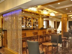 a restaurant with a bar with chairs and a wall of wine bottles at Alfa Hotel in Istanbul
