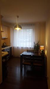 eine Küche und ein Esszimmer mit einem Tisch und einem Fenster in der Unterkunft Apartamentai Dainų II in Šiauliai