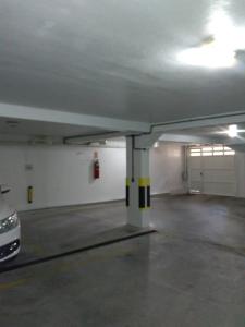 un garage vide avec une voiture garée à l'intérieur dans l'établissement Apartamento Centro Gramado, à Gramado