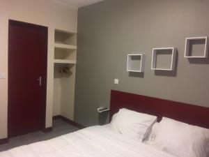 a bedroom with a bed with white sheets and white pillows at HOTEL DE STRASBOURG in Aulnay-sous-Bois