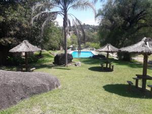 a yard with a swimming pool and some umbrellas at Departamentos Carlos Paz bajada al lago in Villa Carlos Paz