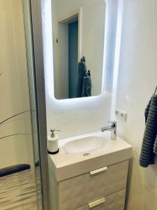 ein Badezimmer mit Waschbecken und Spiegel in der Unterkunft Nordbrise in Büsum + 20 Fotos