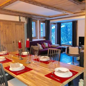 uma sala de jantar com uma grande mesa de madeira com cadeiras em Le Falyoucher em Peisey-Nancroix
