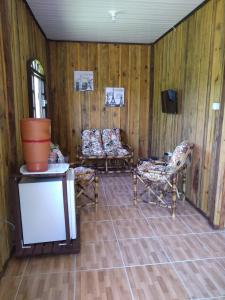 a living room with two chairs and a tv at Pousada Serra Verde Ecolodges in Morretes