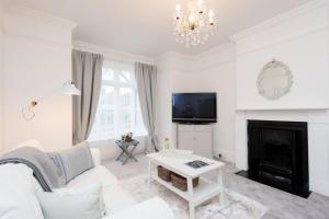 a living room with a white couch and a fireplace at The Mariners Suite in West Mersea