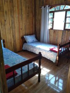 a room with two bunk beds and a window at Pousada Serra Verde Ecolodges in Morretes