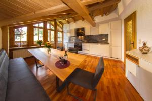 a kitchen and dining room with a wooden table and chairs at Appartement-Hotel-Allgayer in Oy-Mittelberg