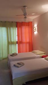 twee bedden in een kamer met een rood gordijn bij Casa da Gente in Rio de Janeiro