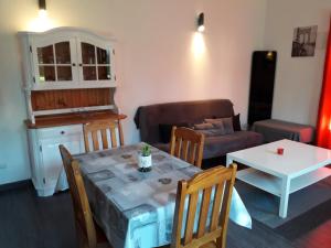 Gîte des Pins Penchés في Brunville: غرفة معيشة مع طاولة وأريكة