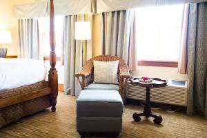 a hotel room with a bed and a chair and a table at Pillar and Post Inn & Spa in Niagara-on-the-Lake
