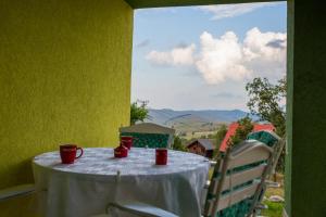 a table with a white table cloth and red cups on it at Vikendica MM in Zlatibor