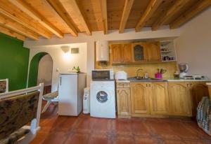 a kitchen with a refrigerator and a washing machine at Vikendica MM in Zlatibor