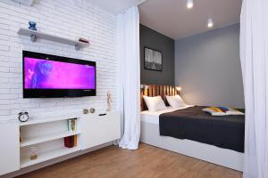 カリーニングラードにあるApartments With River View (Bagramyana 36)のレンガの壁にテレビとベッドが備わるベッドルーム1室が備わります。