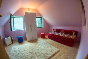 a living room with a red couch in a pink room at Vikendica MM in Zlatibor +7 photos