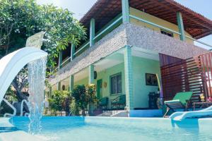 a house with a pool and a water fountain at Pousada Estrela do Oriente in Taíba