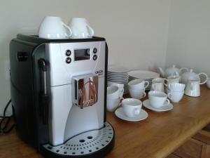 a coffee machine with cups and plates on a table at Blackberry Lodge Accommodation in Doolin