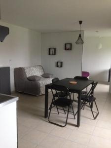 a living room with a table and chairs and a bed at gite des écuries in La Baconnière