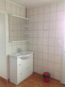 a white bathroom with a sink and a mirror at gite des écuries in La Baconnière