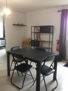 a black table and chairs in a living room at gite des écuries in La Baconnière