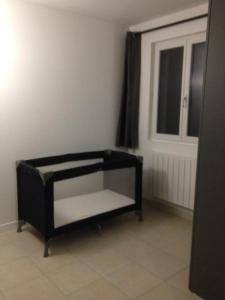 a black bed in a room next to a door at gite des écuries in La Baconnière