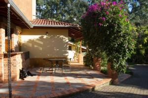 une terrasse avec une table et des chaises dans une maison dans l'établissement Sitio dos Rochedos, à Ivoti