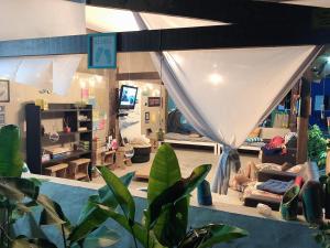 Habitación con sala de estar con sofá. en Farah Hostel Suítes Camping Smartcamp e Passeio de barco, en Boicucanga