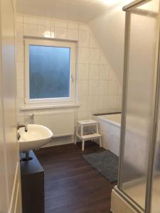 a bathroom with a sink and a tub and a window at Ferienhaus Langenmoor in der Natur! Abschalten in der Abgelegenheit! Haustiere willkommen! in Armstorf