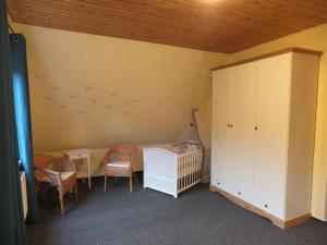 pokój dla dzieci z łóżeczkiem dziecięcym i ptakami na ścianie w obiekcie Ferienhaus Langenmoor in der Natur! Abschalten in der Abgelegenheit! Haustiere willkommen! w mieście Armstorf
