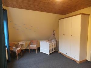 - une chambre bébé avec un lit bébé et des oiseaux sur le mur dans l'établissement Ferienhaus Langenmoor in der Natur! Abschalten in der Abgelegenheit! Haustiere willkommen!, à Armstorf