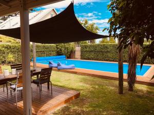 a patio with a table and chairs and an umbrella at Woodstock Suite in Nelson