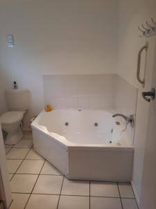 eine weiße Badewanne im Bad mit WC in der Unterkunft Mokau Motels in Mokau