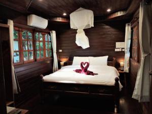 a pink ribbon sitting on a bed in a room at Cozy Garden Resort in Ao Nang Beach