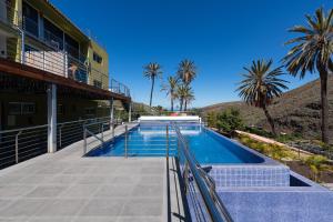 basen obok budynku z palmami w obiekcie Finca Oasis Holidays & Health - Charming Villas w mieście Balcon de Telde