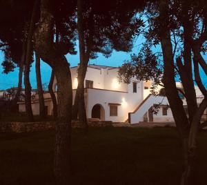 uma casa branca com árvores em frente em Villa Iavernaro em Pulsano