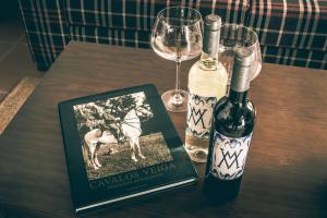 una mesa con dos botellas de vino y un libro en Casas da Piedade en Azinhaga