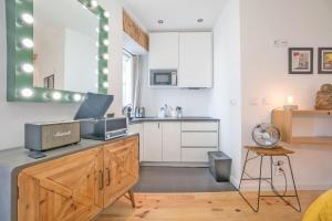 a kitchen with white cabinets and a counter with a microwave at Downtown Comfy Suite in Lisbon