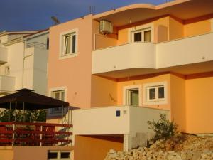 ein Gebäude mit einem Balkon und einem Sonnenschirm in der Unterkunft Apartments Sanja in Hvar