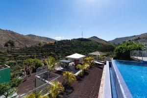 Balcon de TeldeにあるHolidays & Health Finca Oasis - Villa 8のスイミングプールと山々のあるリゾートの景色を望めます。