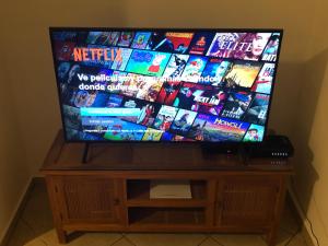 a flat screen tv sitting on top of a wooden stand at Casa Caribe Appartamento Attico in Bayahibe