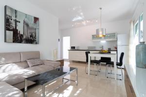 un soggiorno con divano e tavolo con sedie di Holidays & Health Finca Oasis - Villa 8 a Balcon de Telde